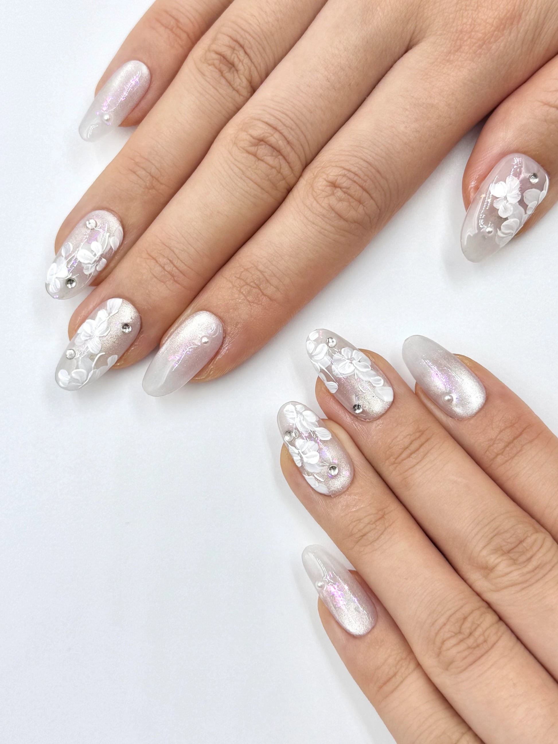 Glowy Silver White Cat-Eye Oval Press-On Nails with Handpainted White Florals, Shiny Crystal Jewelry and Pink Iridescent shimmer
