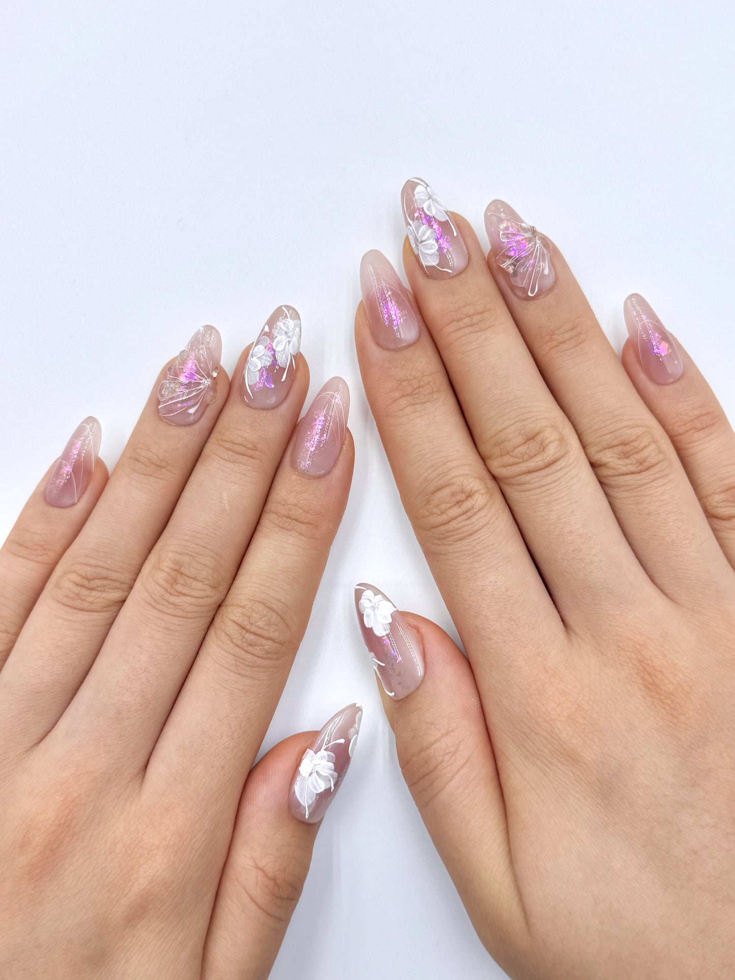 Soft Nude Almond Oval Press-On Nails with Handpainted White Florals, Pink Iridescent Shimmer and 3D Gel Butterfly Wing